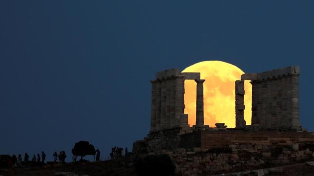 People watch a full moon rising behind the Temple of Poseidon before a lunar eclipse in Cape Sounion, near Athens, Greece. (Alkis Konstantinidis / REUTERS) People watch a full moon rising behind the Temple of Poseidon before a lunar eclipse in Cape Sounion, near Athens, Greece. (Alkis Konstantinidis / REUTERS)