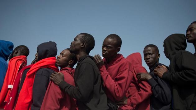 Migrants rescued at sea wait to be transferred at the harbour of Algeciras. There are not enough officers to process migrants within 72 hours of their arrival as required by law. In a sign that police are struggling to control the situation, 62 migrants escaped on Sunday from a warehouse which has been turned into a temporary shelter in the port of Barbate in Cadiz. (Jorge Guerrero / AFP)