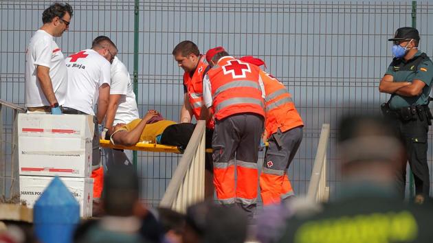 A migrant woman, intercepted aboard a dinghy off the coast in the Strait of Gibraltar, is carried on a stretcher by the Spanish Red Cross. Police and charities that work with migrants have said that the surge is exposing Spain’s response as unplanned, underfunded and understaffed. Interior Minister Fernando Grande-Marlaska has however said that situation is “absolutely under control and controllable.” (Jon Nazca / REUTERS)
