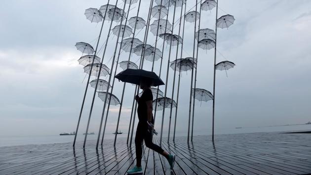 A woman with an umbrella walks under the rain past a sculpture called ‘Umbrellas’ by Greek sculptor George Zongolopoulos along the waterfront in Thessaloniki, Greece. (Sakis Mitrolidis / AFP) A woman with an umbrella walks under the rain past a sculpture called ‘Umbrellas’ by Greek sculptor George Zongolopoulos along the waterfront in Thessaloniki, Greece. (Sakis Mitrolidis / AFP)