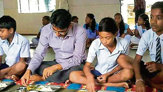 Sundargarh district collector Surendra Kumar Meena shares midday meal with students of a government school in Odisha.(HT Photo)