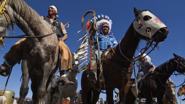 Harold Frazier, (C) Chairman of the Cheyenne River Reservation wears his Lakota headdress and holds a staff. He said in his speech at Fort Laramie, “I carry this staff for Cheyenne River Lakota Akichita (Lakota for relatives or people) to remind me to be a warrior for our people.” After riding almost the entire way, Frazier still felt disappointed that while Wyoming Senator John Barrasso attended no other federal senior officials were there. (Stephanie Keith / REUTERS)