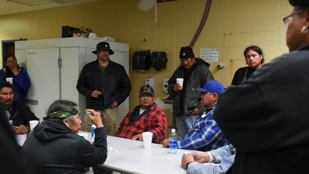 Ivan Lookinghorse (C) and other riders meet in a school kitchen in South Dakota. “Understand that we, as a people, we have been in poverty, we have been in depression, we have been Christianised, we have been boarding schooled, our language has been taken away from us, but we are on our way back to who we once were,” Lookinghorse said. “We are taking our place in the world, the protectors of the Grandmother Earth.” (Stephanie Keith / REUTERS)