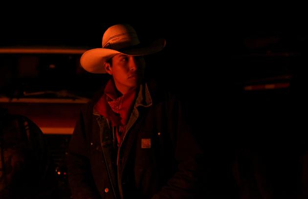 Wyatt Grey is seen by the light of a campfire during an overnight stop in Harrison, Nebraska. With Fort Laramie two days away, people excitedly wondered which other Native groups would be there and who would represent the federal government. There were ceremonies and drumming, tepees were pitched, people visited around fires. (Stephanie Keith / REUTERS)