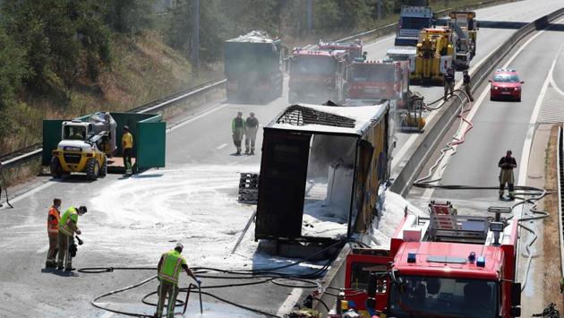 Firefighters work at the scene of a burned-out truck on the E19 highway from Mechelen to Brussels, at Machelen. The Belgian road safety authority VIAS reported an increase in the number of road accidents as a result of the heatwave. “The daily average number of accidents is 15% higher during a heatwave,” VIAS spokesman, Stef Willems, was quoted saying. (Benoit Doppagne / Belga / AFP) 