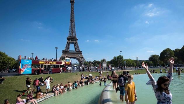 People cool themselves at the Trocadero Fountain in front of The Eiffel Tower in Paris. Wide swathes of the country have been placed on heatwave alert with the health ministry rolling out a TV and radio campaign alerting people to the dangers of what is expected to be the most intense heatwave since 2006. (Gerard Julien / AFP) 
