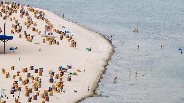 Holdiaymakers bathe at the Baltic Sea beach of Laboe, northern Germany. Tourism operators, such as Thomas Cook and Alltours, were quoted by German news agency DPA as saying that last-minute bookings for the Mediterranean are down, as holidaymakers seek out cooler temperatures on the North Sea and Baltic coastlines. (Frank Molter / dpa / AFP) 