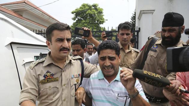 A police officer assists a man whose son was killed inside the residence of Farooq Abdullah, member of parliament and Kashmir's former top elected official, outside the residence on the outskirts of Jammu, India, Saturday, Aug. 4, 2018. (AP Photo) A police officer assists a man whose son was killed inside the residence of Farooq Abdullah, member of parliament and Kashmir's former top elected official, outside the residence on the outskirts of Jammu, India, Saturday, Aug. 4, 2018. (AP Photo)