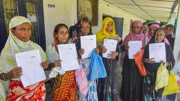 Women queue up to verify and check their names in the final draft of the National Register of Citizens (NRC), at Morigoan.(PTI)