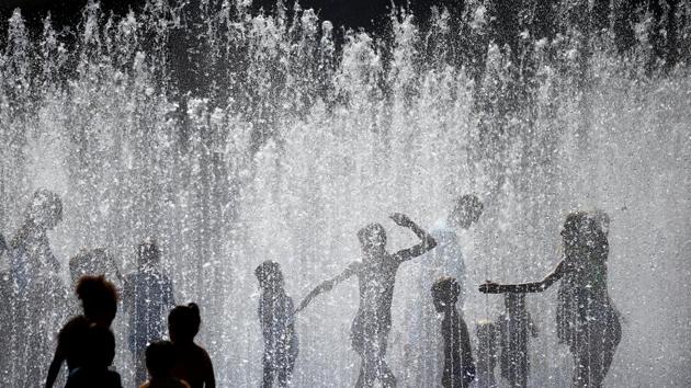 People play amongst the fountains outside the Royal Festival Hall in London, England. The heatwave has hit British retail sales, which were down 1.1% in July, according to accountancy firm BDO. (Henry Nicholls / REUTERS) 