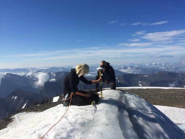 Gunhild Ninis Rosqvist, a Stockholm University geography professor takes measurements atop Sweden's highest peak, a glacier on the southern tip of the Kebnekaise mountain in northern Sweden. The peak is no longer the nation’s tallest point, scientists said on August 1, 2018. (Carl Lundberg / Stockholm University / AFP) 