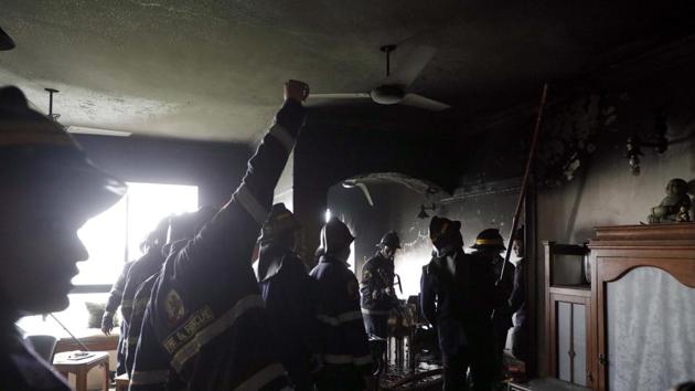 Fire fighters dose a fire in a flat on 11th floor of Maestros at Wanowrie on Wednesday. No one was injured in the incident. (Rahul Raut/HT PHOTO)