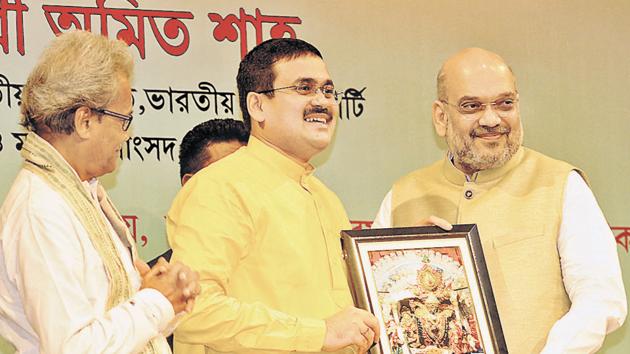 Anirban Ganguly, a member of the BJP’s policy­making wing, presents party president Amit Shah with a photo of Goddess Kali, Bengal’s popular goddess.(Samir Jana/HT file photo)