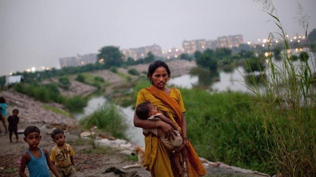 A woman breastfeeds as she walks in a shanty encampment for labourers near the site of the Commonwealth Games village in New Delhi. The restrictive atmosphere prompts many mothers to stay at home, exposing them to the risk of postnatal depression, while also acting as a brake on getting women into the workforce. (Daniel Berehulak / Getty Images) 