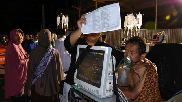 A person evacuated to the parking lot outside the Mataram City hospital with other patients. The quake, measured at 7.0 magnitude by Indonesian authorities and a still-powerful 6.9 by the US Geological Survey, struck early Sunday evening at a depth of 10.5km in the northern part of Lombok and triggered a tsunami warning. (Ahmad Subaidi / Antara Foto / REUTERS) A person evacuated to the parking lot outside the Mataram City hospital with other patients. The quake, measured at 7.0 magnitude by Indonesian authorities and a still-powerful 6.9 by the US Geological Survey, struck early Sunday evening at a depth of 10.5km in the northern part of Lombok and triggered a tsunami warning. (Ahmad Subaidi / Antara Foto / REUTERS)