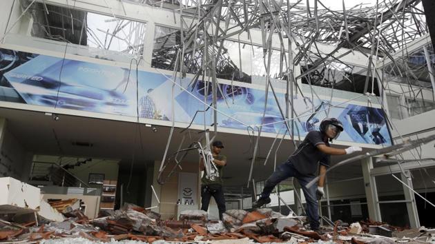 Workers remove the debris at a building damaged in Bali. Some areas still hadn’t been reached, with rescuers hampered by collapsed bridges, electricity blackouts and damaged roads blocked with debris. (Firdia Lisnawati / AP) Workers remove the debris at a building damaged in Bali. Some areas still hadn’t been reached, with rescuers hampered by collapsed bridges, electricity blackouts and damaged roads blocked with debris. (Firdia Lisnawati / AP)