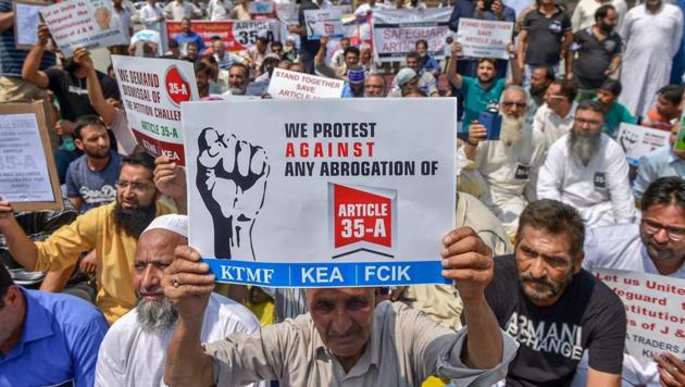 Kashmiri traders hold placards and raise slogans during a sit-in protest against the petitions in the Supreme court challenging the validity of Article 35A, in Srinagar on Sunday, August 05, 2018. (PTI) Kashmiri traders hold placards and raise slogans during a sit-in protest against the petitions in the Supreme court challenging the validity of Article 35A, in Srinagar on Sunday, August 05, 2018. (PTI)