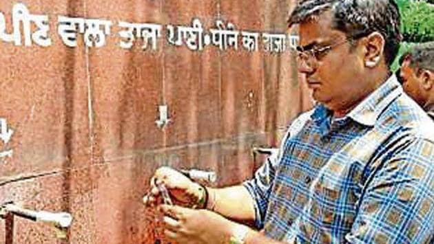 Health inspector checking water sample from one of the taps at Ludhiana railway station on Monday(HT Photo)