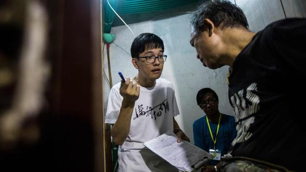 Fixing Hong Kong member Max Leung (L) speaks with a resident of a subdivided flat who requested a fridge repair. Leung said that they hope to gather more energy bit by bit through contact and bonding. The trend also taps into young people’s desire to reconnect with their surroundings as private housing estates and shopping malls erode a sense of community living, says researcher Klavier Wong. (Isaac Lawrence / AFP)