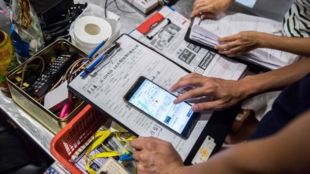 Volunteers look up an address for a repair job. Pro-democracy politicians have been criticised for losing touch with the grassroots while some pro-Beijing candidates have become more strategically focused on working-class voters and livelihood issues. But small groups like Fixing Hong Kong believe going back to neighbourhoods is the best way to rebuild support. (Isaac Lawrence / AFP)