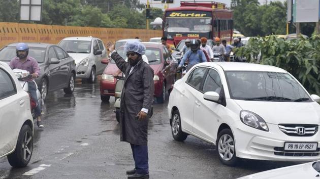 Head constable Sucha Singh managing the traffic on the Ferozepur road in rain on Tuesday. (HT Photo) Head constable Sucha Singh managing the traffic on the Ferozepur road in rain on Tuesday. (HT Photo)