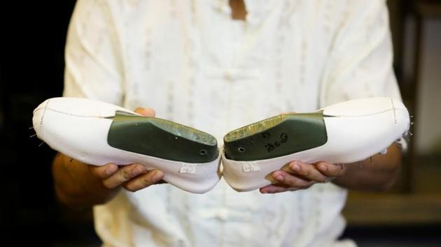 Cai Wenke inspects a pair of cloth shoes at the demonstration workshop. Despite their name however, the shoes don’t necessarily have as many as a thousand layers. The term rather stresses the strength and durability of the product itself. Nowadays, a more modest 35 layers of cotton are interwoven with hemp thread in a criss-cross fashion. (Thomas Peter / REUTERS) Cai Wenke inspects a pair of cloth shoes at the demonstration workshop. Despite their name however, the shoes don’t necessarily have as many as a thousand layers. The term rather stresses the strength and durability of the product itself. Nowadays, a more modest 35 layers of cotton are interwoven with hemp thread in a criss-cross fashion. (Thomas Peter / REUTERS)