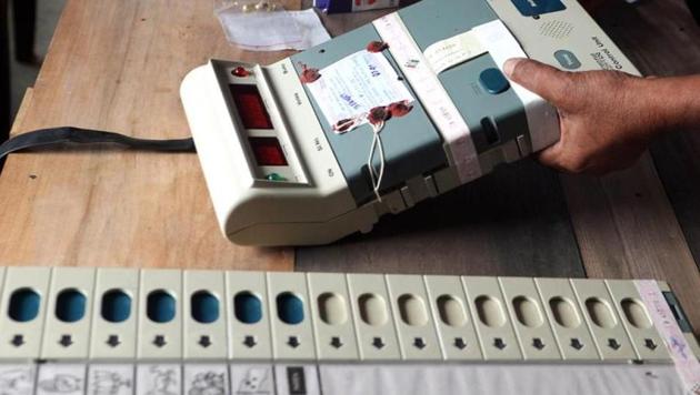 Election Commission officials seal an Electronic Voting Machine (EVM) prior to the start of voting at a polling station.(AFP File Photo)