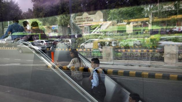 Commuters ride an escalator from Japnath metro station as vehicles are sitting in traffic are reflected in a window in New Delhi. India is on track to hold its position as one of the world’s fastest-growing economies as reforms start to pay off, according to the International Monetary Fund. (Bloomberg) Commuters ride an escalator from Japnath metro station as vehicles are sitting in traffic are reflected in a window in New Delhi. India is on track to hold its position as one of the world’s fastest-growing economies as reforms start to pay off, according to the International Monetary Fund. (Bloomberg)