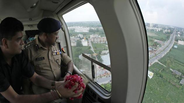 Meerut district magistrate Anil Dhingra (L) and senior superintendent of police (SSP) of Meerut Rajesh Kumar Pandey (R) prepare to sprinkle rose petals over devotees of Hindu God Shiva, "Kanwariyas", carrying pots of Holy Ganga water on their return journey from Haridwar during an aerial inspection in Meerut on August 8, 2018. (AFP Photo) Meerut district magistrate Anil Dhingra (L) and senior superintendent of police (SSP) of Meerut Rajesh Kumar Pandey (R) prepare to sprinkle rose petals over devotees of Hindu God Shiva, "Kanwariyas", carrying pots of Holy Ganga water on their return journey from Haridwar during an aerial inspection in Meerut on August 8, 2018. (AFP Photo)