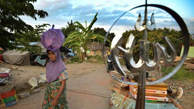 A woman carries her belongings on her head as she walks past a damaged mosque in Kayangan subdistict. Workers with heavy machinery are searching the rubble of homes, schools and mosques, with hope of finding any survivors fading. There are fears that two collapsed mosques in north Lombok had been filled with worshippers. (Sonny Tumbelaka / AFP) A woman carries her belongings on her head as she walks past a damaged mosque in Kayangan subdistict. Workers with heavy machinery are searching the rubble of homes, schools and mosques, with hope of finding any survivors fading. There are fears that two collapsed mosques in north Lombok had been filled with worshippers. (Sonny Tumbelaka / AFP)