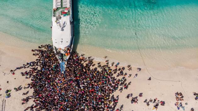 People crowd the beach as they wait to be evacuated from Gili Trawangan island. Thousands of tourists have left Lombok since Sunday, fearing further earthquakes, some on extra flights provided by airlines and others on ferries to the neighbouring island of Bali. (Melissa Delport / @trufflejournal / AFP) People crowd the beach as they wait to be evacuated from Gili Trawangan island. Thousands of tourists have left Lombok since Sunday, fearing further earthquakes, some on extra flights provided by airlines and others on ferries to the neighbouring island of Bali. (Melissa Delport / @trufflejournal / AFP)