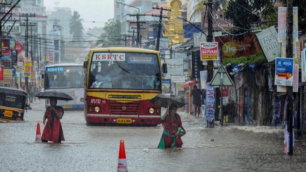 Pedestrians and commuters wade through a flooded street during monsoon rainfall, in Thiruvananthapuram on Tuesday, July 31, 2018.(PTI File)