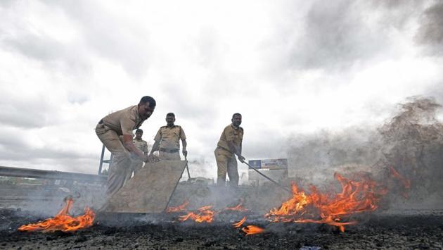 Police personnel clear tires which were set on fire by protesters during Maratha agitation on Pune-Banglore highway in Pune, Maharashtra on August 09, 2018. (Pratham Gokhale / HT Photo) Police personnel clear tires which were set on fire by protesters during Maratha agitation on Pune-Banglore highway in Pune, Maharashtra on August 09, 2018. (Pratham Gokhale / HT Photo)