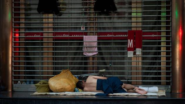 A man sleeps in front of a shopping mall along Nanjing East Road. The city of more than 24 million people has endured an extended hot spell over recent weeks, with temperatures on Thursday topping 35 degrees Celsius for the 16th day this summer. (Johannes Eisele / AFP) A man sleeps in front of a shopping mall along Nanjing East Road. The city of more than 24 million people has endured an extended hot spell over recent weeks, with temperatures on Thursday topping 35 degrees Celsius for the 16th day this summer. (Johannes Eisele / AFP)