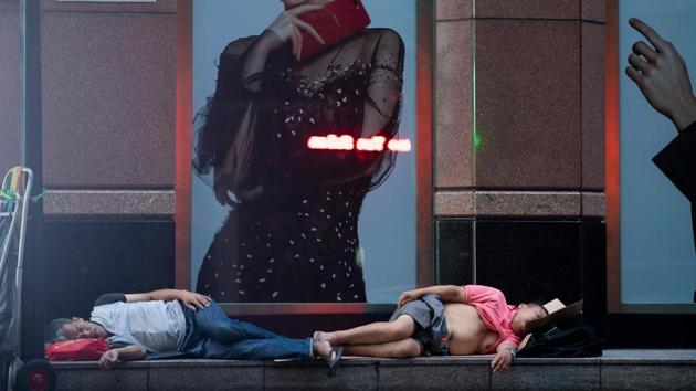 Normally bustling Nanjing East Road has turned into an open-air slumber party on recent nights as local residents try to escape the heat of their cramped nearby homes by sleeping outside on benches or directly on the pavement. (Johannes Eisele / AFP) Normally bustling Nanjing East Road has turned into an open-air slumber party on recent nights as local residents try to escape the heat of their cramped nearby homes by sleeping outside on benches or directly on the pavement. (Johannes Eisele / AFP)