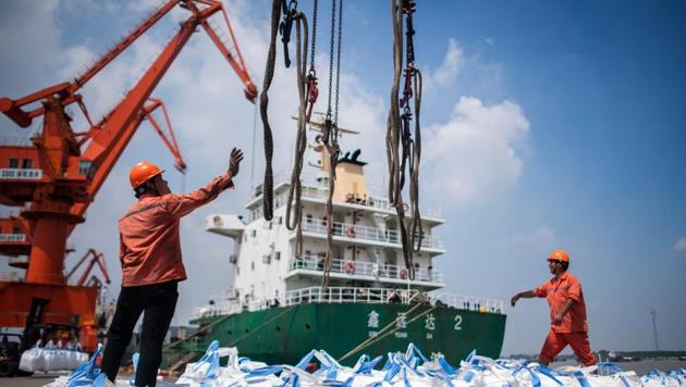 Workers unloading bags of chemicals at a port in Zhangjiagang in China's eastern Jiangsu province. (AFP Photo) Workers unloading bags of chemicals at a port in Zhangjiagang in China's eastern Jiangsu province. (AFP Photo)
