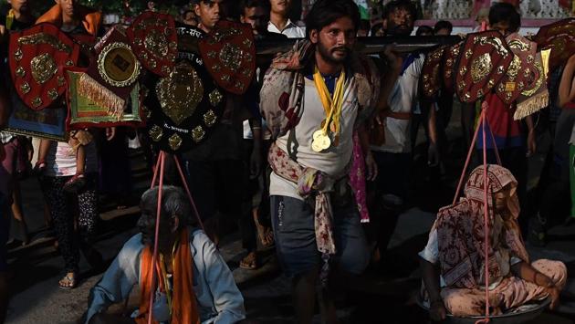 Rahul (C), a devotee of Shiva, carries his 90-year-old grandfather Chote Lal (L) and 80-year-old grandmother Kashmira on his shoulders along with pots of Holy Ganga water on his return journey from Haridwar, at Baba Augharnath Shiv Mandir in Meerut, Uttar Pradesh on August 08, 2018. (Prakash Singh / AFP) Rahul (C), a devotee of Shiva, carries his 90-year-old grandfather Chote Lal (L) and 80-year-old grandmother Kashmira on his shoulders along with pots of Holy Ganga water on his return journey from Haridwar, at Baba Augharnath Shiv Mandir in Meerut, Uttar Pradesh on August 08, 2018. (Prakash Singh / AFP)