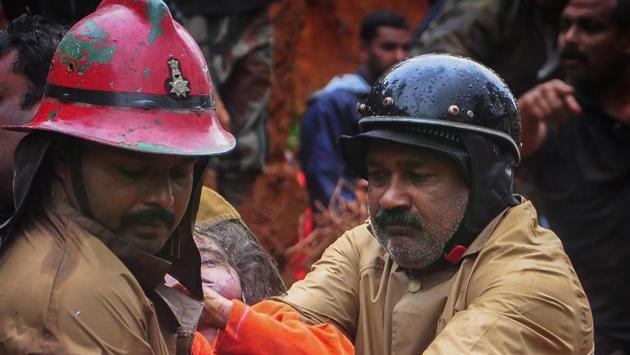 Fire Services personnel rescue a child following a landslide in Idukki, Kerala on Thursday (PTI)