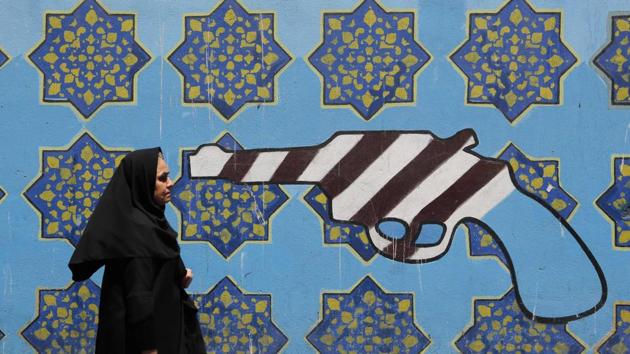 An Iranian woman walks past a mural depicting a gun painted on the wall of the former US embassy in the capital Tehran. (Atta Kenare / AFP) An Iranian woman walks past a mural depicting a gun painted on the wall of the former US embassy in the capital Tehran. (Atta Kenare / AFP)