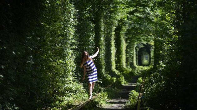 A girl walks along former railway tracks in the so-called ‘Tunnel of Love’, surrounded by arches of intertwined trees, near the Ukrainian village of Klevan, Rivno region. (Sergei Supinsky / AFP) A girl walks along former railway tracks in the so-called ‘Tunnel of Love’, surrounded by arches of intertwined trees, near the Ukrainian village of Klevan, Rivno region. (Sergei Supinsky / AFP)