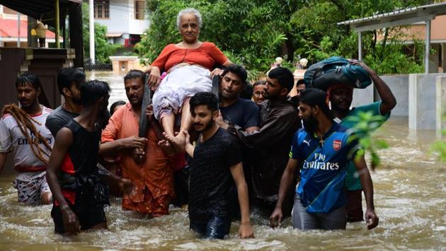 An elderly woman being rescued by residents after a flash flood hits Palakkad, Kerala. (PTI)