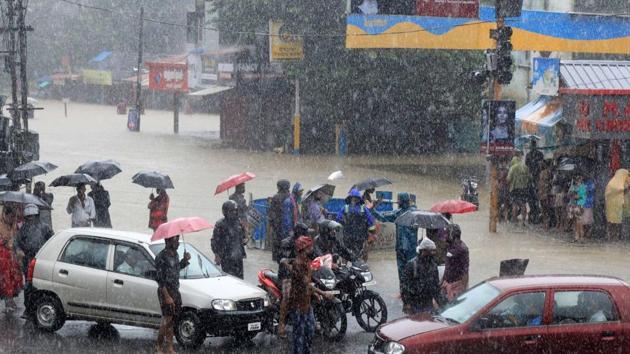 People stranded at a flooded junction following a flash flood, triggered by heavy rains, at Palakkad in Kerala on Thursday, Aug 9, 2018.(PTI)