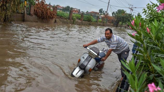 A man pushes his scooter through a waterlogged road after rains in Srinagar, Jammu and Kashmir on August 7, 2018. (S Irfan / PTI) A man pushes his scooter through a waterlogged road after rains in Srinagar, Jammu and Kashmir on August 7, 2018. (S Irfan / PTI)