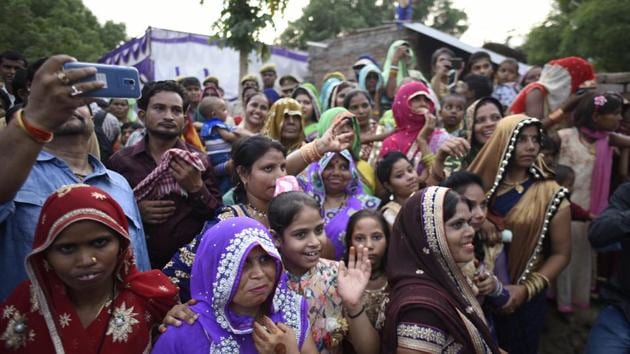 Family members of the bride welcome the incoming wedding procession. As Jatav’s convoy entered the village, greeted by a phalanx of press, senior police and administration officers and political leaders cutting across party lines, even the Thakur families left everything they were doing and rushed to their rooftops to witness the breach of the village “tradition”. (Burhaan Kinu / HT Photo) Family members of the bride welcome the incoming wedding procession. As Jatav’s convoy entered the village, greeted by a phalanx of press, senior police and administration officers and political leaders cutting across party lines, even the Thakur families left everything they were doing and rushed to their rooftops to witness the breach of the village “tradition”. (Burhaan Kinu / HT Photo)
