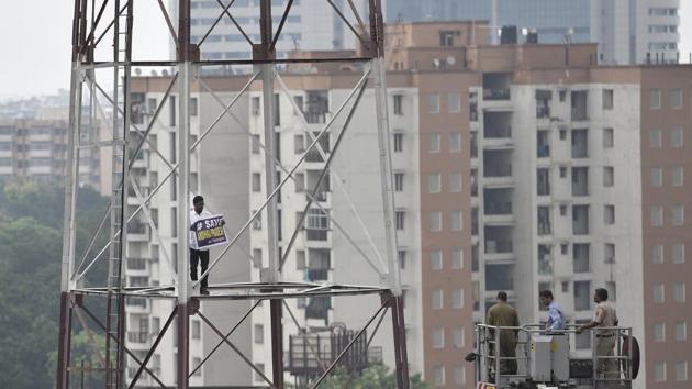 Fire fighters try to take down a man who climbed the Fire Station tower to demand special status for Andhra Pradesh at Connaught Place in New Delhi on Friday.(Sanchit Khanna/HT Photo) Fire fighters try to take down a man who climbed the Fire Station tower to demand special status for Andhra Pradesh at Connaught Place in New Delhi on Friday.(Sanchit Khanna/HT Photo)