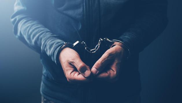 Arrested computer hacker and cyber criminal with handcuffs, close up of hands(Getty Images/iStockphoto)