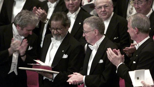 Writer VS Naipaul (2L) looks over his Nobel prize for literature with Medicine winner Sir Paul Nurse (L) and Economics winners George Akerlof and A. Michael Spence (R) at Stockholm’s Konserthuset, after receiving it from Sweden’s King Carl Gustaf on December 10, 2001. When he was awarded the prize, the Swedish Academy described him as a “literary circumnavigator, only ever really at home in himself, in his inimitable voice.” (Chris Helgren / REUTERS File) 