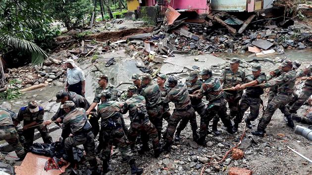 Soldiers clear debris off a road in a flood-affected area at Wayanad. (PTI)