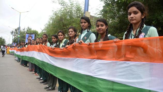 Students hold a tricolour which is said to be 12-km long, ahead of Independence Day, in Indore on Sunday. Uttar Pradesh Shia Waqf Board has told all madrassas functioning from its properties to celebrate the Independence Day by chanting ‘Bharat Mata Ki Jai’ after hoisting the national flag and singing the national anthem.(Representative Image/PTI Photo)