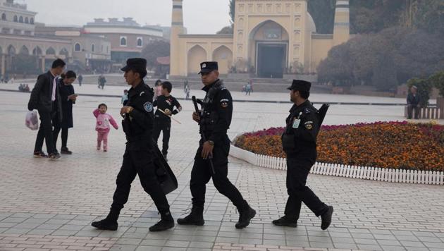 Uyghur security personnel patrol near the Id Kah Mosque in Kashgar in western China's Xinjiang region on November 4, 2017.(AP Photo)